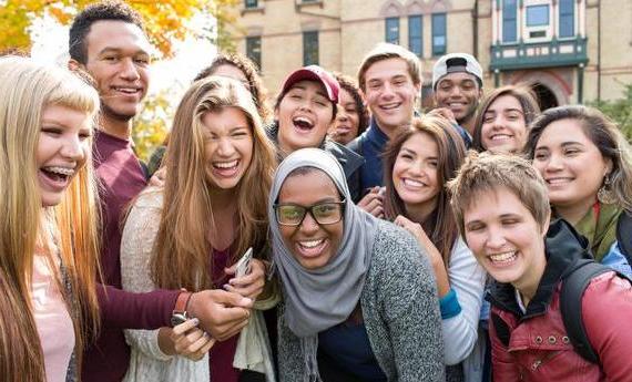 一群微笑, 笑着的体育博彩app学生聚集在老梅因门前，靠在一起拍照